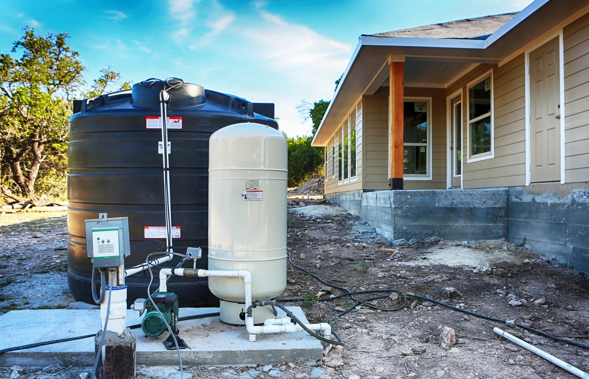 Drilled draw well with pressure switch and storage tank