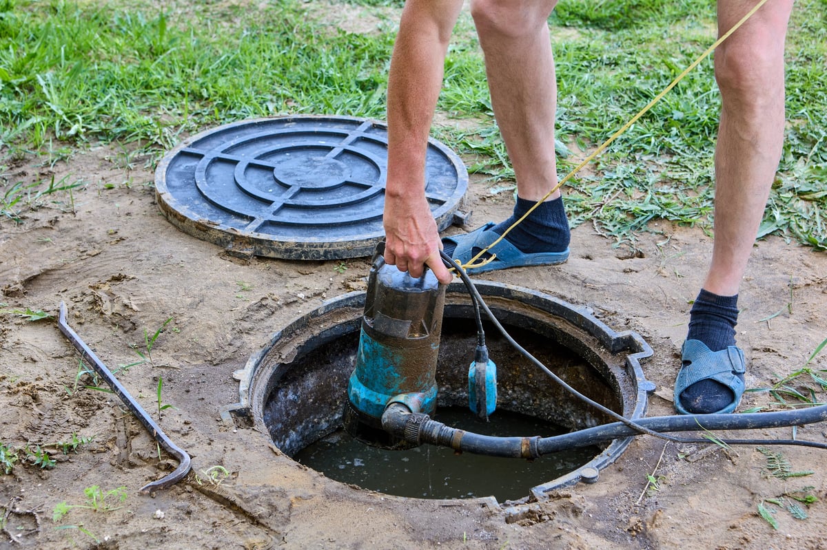 Worker pumping water from septic tank system