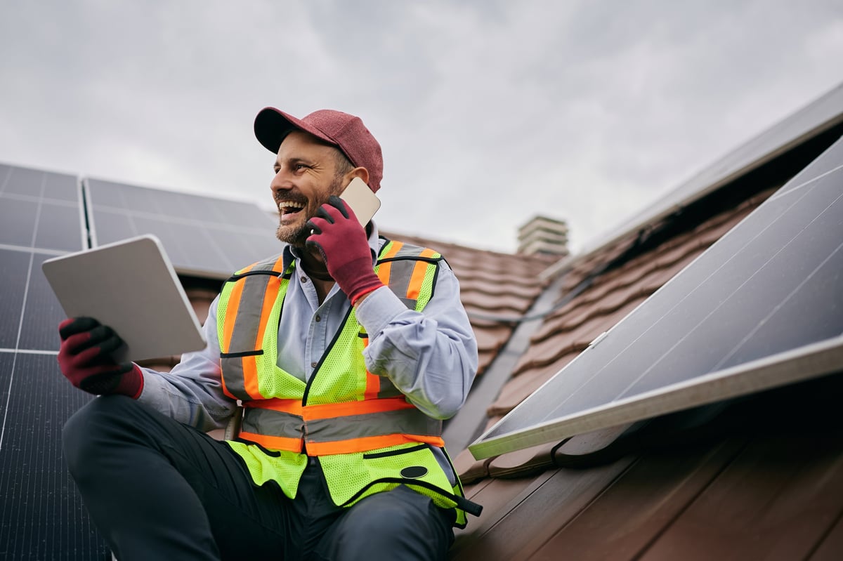 Solar panel technician working on roof