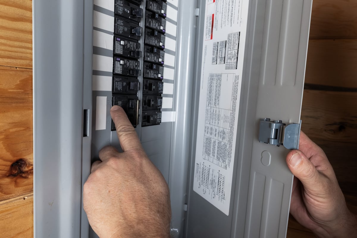 Close up of a home owner inspecting the electrical breakers or fuse box to restore power